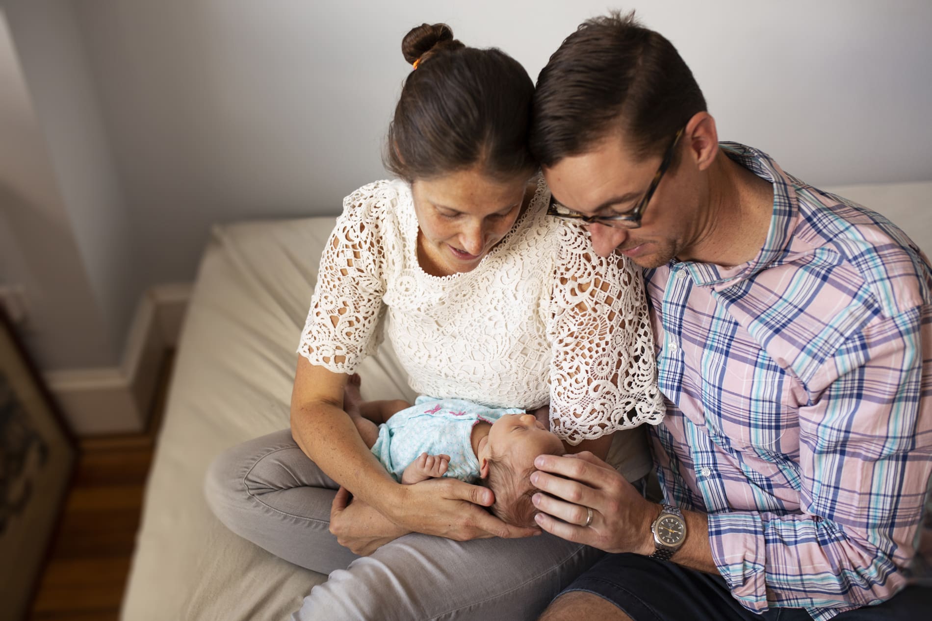newborn baby girl mom dad parents bed snuggle lap