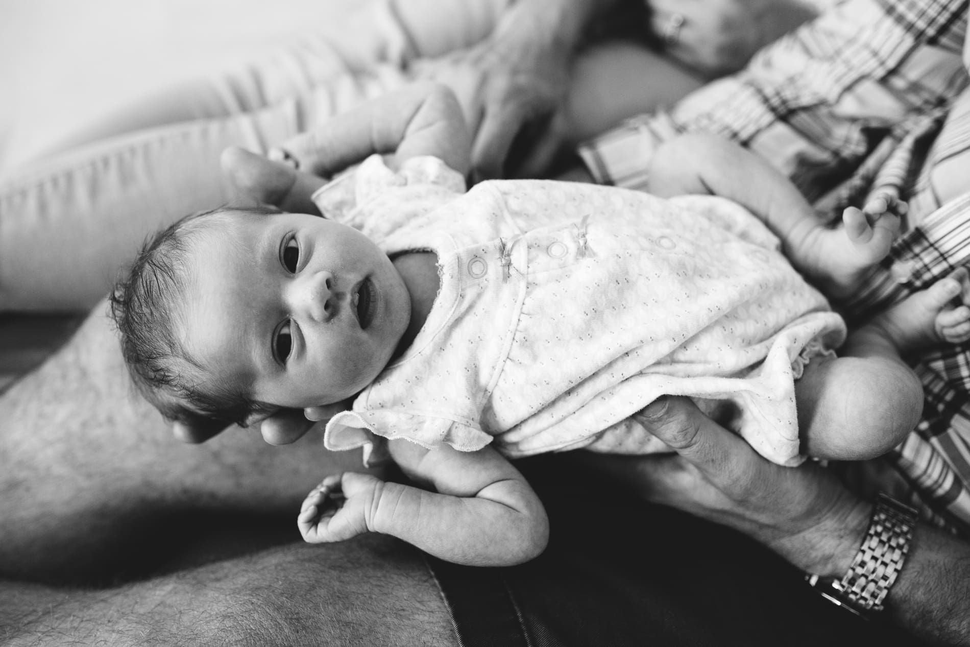 black white photo newborn baby girl dad holding awake
