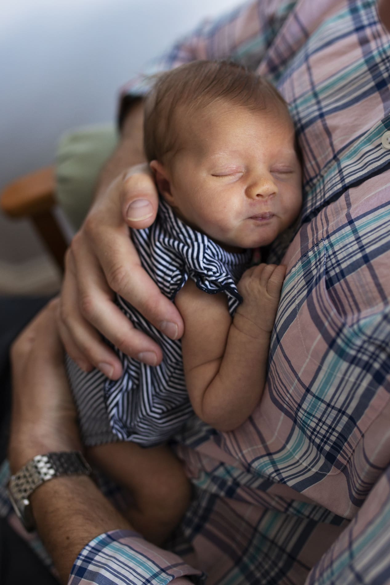 newborn baby girl snuggling sleeping on dad chest