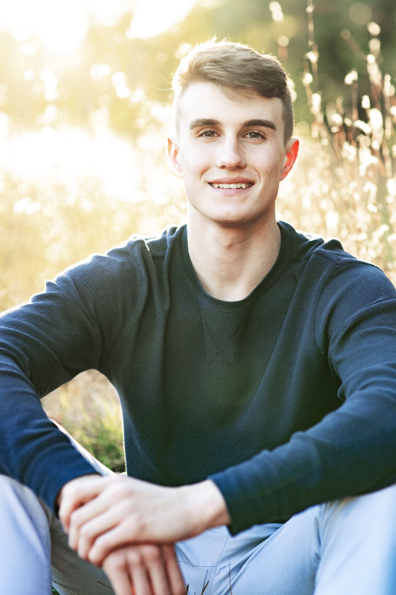 golden hour senior guy photo session with sunlight over field