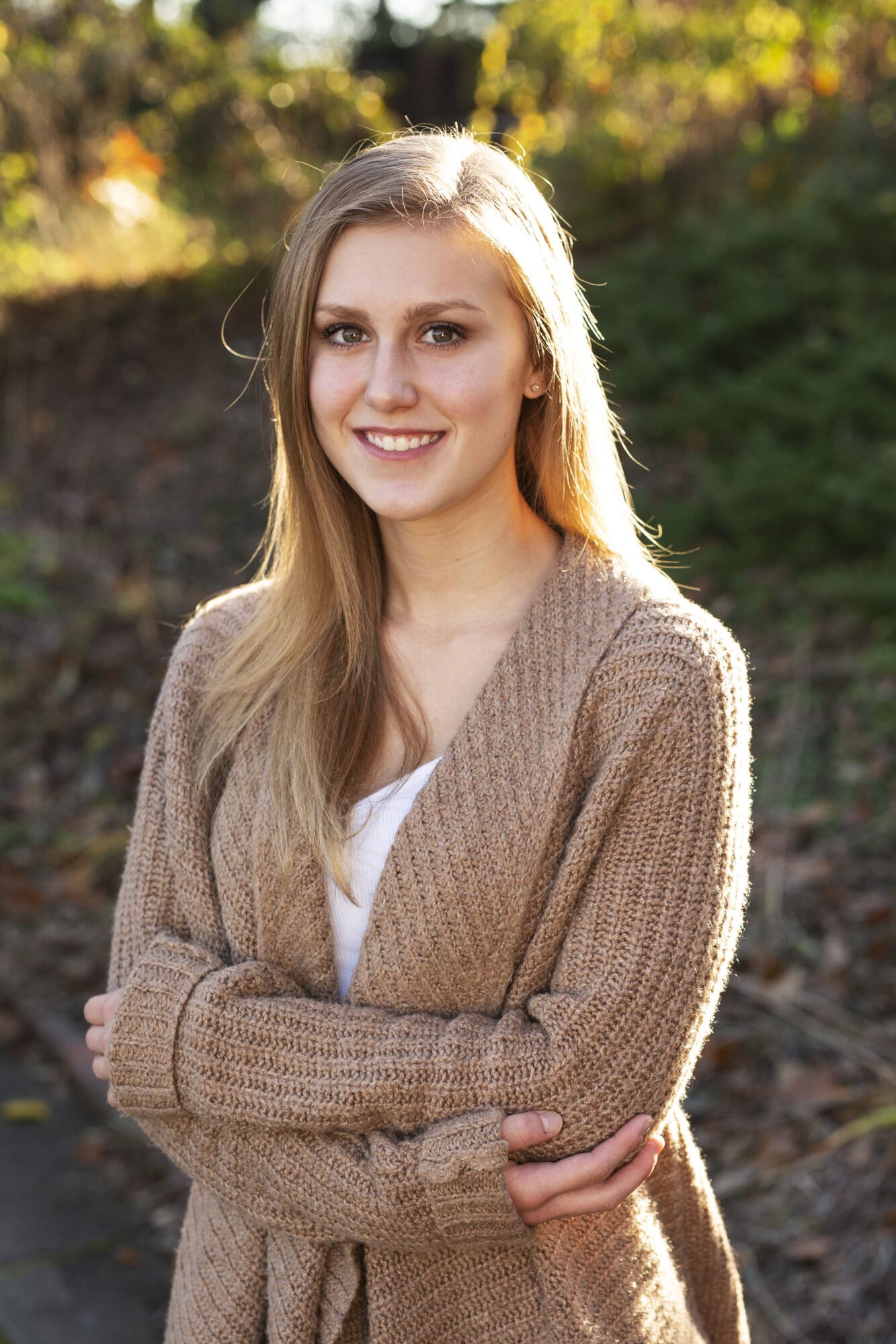 blond senior girl portrait headshot with sun shining on her hair