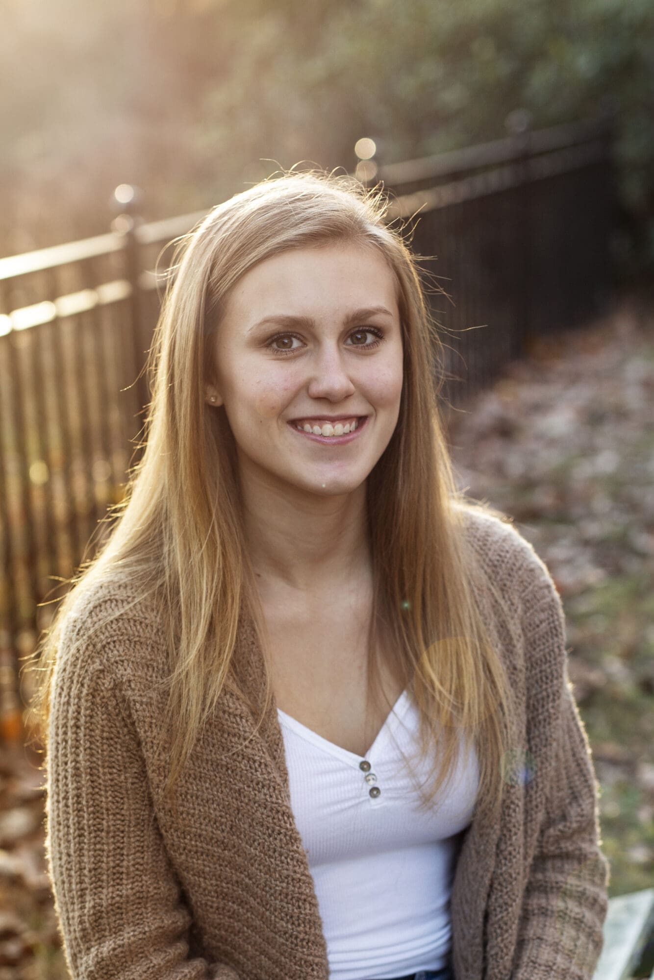 senior girl sitting photo with golden hour light and bokeh