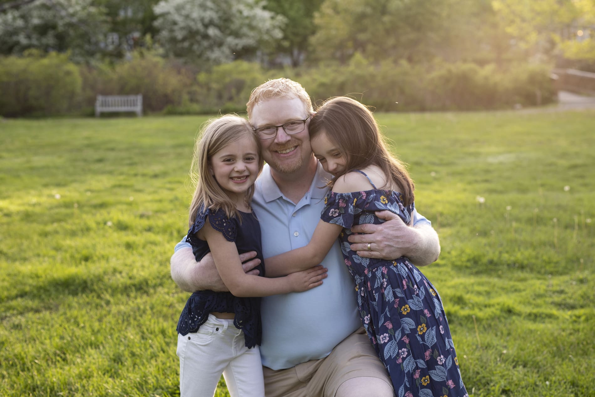 father hugging two daughters girls acton arboretum massachusetts spring